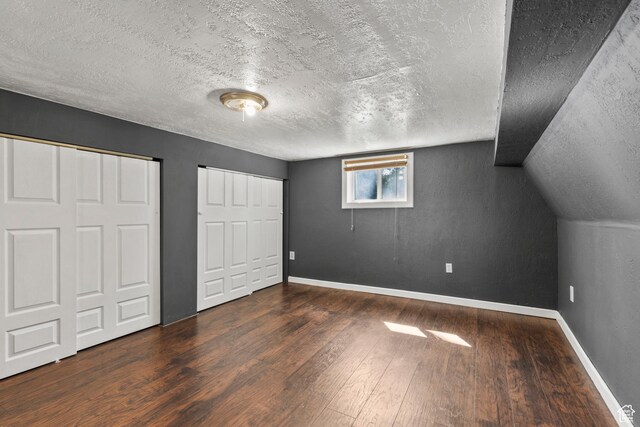 165 N 800 E, Hyrum, UT 84319 - unfurnished bedroom featuring wood-type flooring, a textured ceiling, two closets, and lofted ceiling