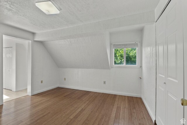 165 N 800 E, Hyrum, UT 84319 - additional living space with hardwood / wood-style flooring, a textured ceiling, and lofted ceiling