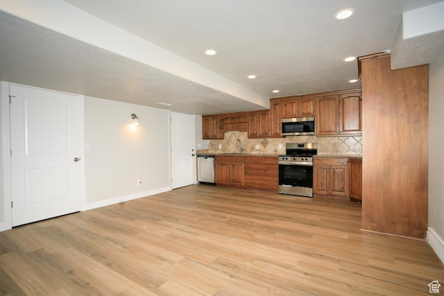 1103 Vista Dr, Santaquin, UT 84655 - kitchen with appliances with stainless steel finishes, tasteful backsplash, brown cabinetry, light wood-type flooring, and recessed lighting