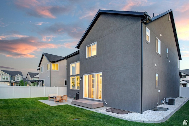 1476 W Stone Gate Dr, Saratoga Springs, UT 84045 - back of house at dusk featuring a patio area and stucco siding
