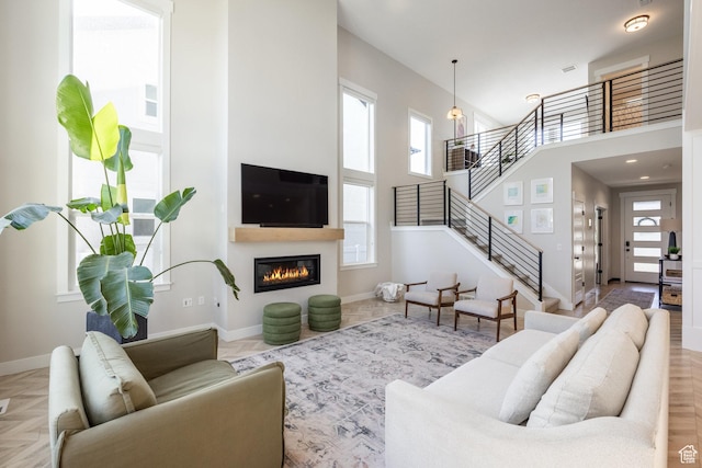 1476 W Stone Gate Dr, Saratoga Springs, UT 84045 - living area with stairs, a towering ceiling, and a glass covered fireplace