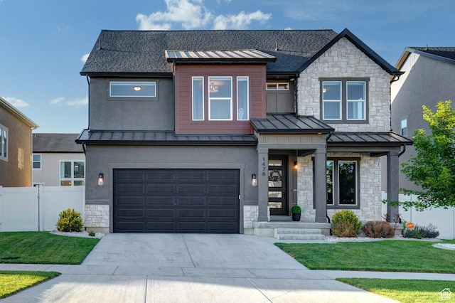 1476 W Stone Gate Dr, Saratoga Springs, UT 84045 - view of front facade featuring a standing seam roof, stone siding, an attached garage, and driveway