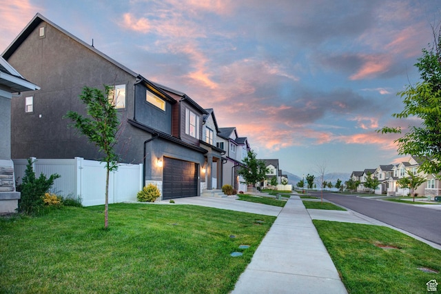1476 W Stone Gate Dr, Saratoga Springs, UT 84045 - property exterior at dusk featuring a residential view, an attached garage, driveway, stucco siding, and stone siding