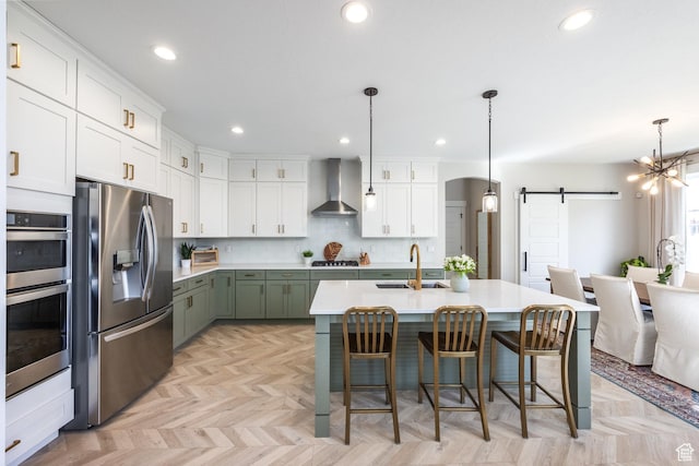 1476 W Stone Gate Dr, Saratoga Springs, UT 84045 - kitchen with appliances with stainless steel finishes, wall chimney range hood, a barn door, white cabinetry, and recessed lighting