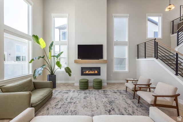 1476 W Stone Gate Dr, Saratoga Springs, UT 84045 - living area with healthy amount of natural light, a glass covered fireplace, and stairway