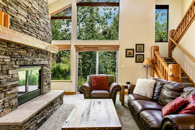8437 Pointe Dr, Park City, UT 84098 - living area featuring stairway, a towering ceiling, carpet, plenty of natural light, and a stone fireplace