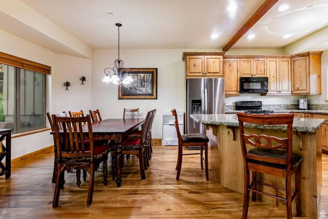 8437 Pointe Dr, Park City, UT 84098 - kitchen with black microwave, stove, stainless steel fridge, wood finished floors, and a center island
