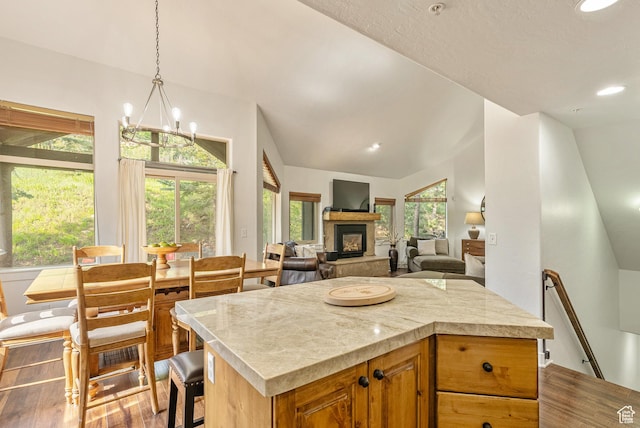 5150 Cove Canyon Dr Unit A, Park City, UT 84098 - kitchen featuring vaulted ceiling, dark wood-style flooring, light countertops, a fireplace with raised hearth, and a chandelier