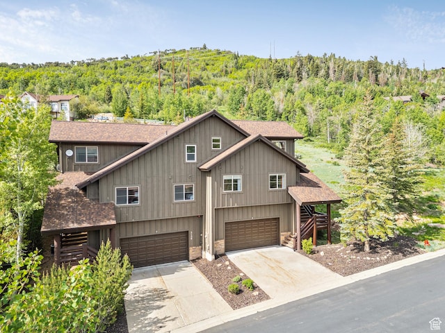 5150 Cove Canyon Dr Unit A, Park City, UT 84098 - view of front of house with a shingled roof, a view of trees, a garage, stairs, and driveway