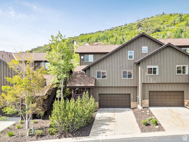 5150 Cove Canyon Dr Unit A, Park City, UT 84098 - view of front of house with an attached garage, driveway, a shingled roof, and stone siding