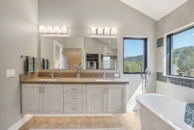 2570 Aspen Springs Dr, Park City, UT 84060 - full bathroom featuring a freestanding bath, lofted ceiling, a shower stall, double vanity, and wood finished floors