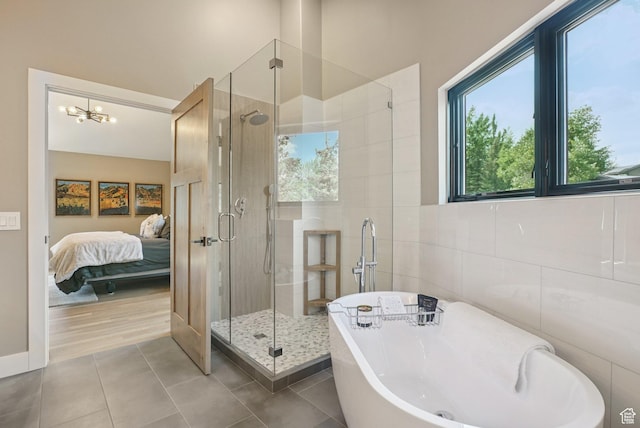 2570 Aspen Springs Dr, Park City, UT 84060 - bathroom featuring a freestanding bath, tile walls, a shower stall, tile patterned floors, and a chandelier