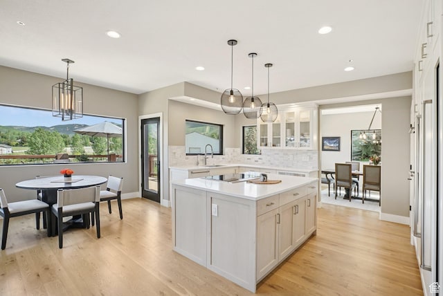 2570 Aspen Springs Dr, Park City, UT 84060 - kitchen featuring a chandelier, light countertops, backsplash, glass insert cabinets, and recessed lighting