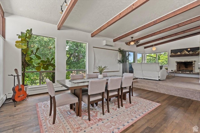 4560 S Wallace Ln, Holladay, UT 84117 - dining area with a wall mounted air conditioner, beam ceiling, a fireplace with raised hearth, dark wood-style flooring, and a textured ceiling