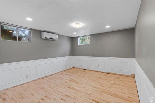 4560 S Wallace Ln, Holladay, UT 84117 - basement with a wall mounted air conditioner, a decorative wall, wood finished floors, wainscoting, and recessed lighting
