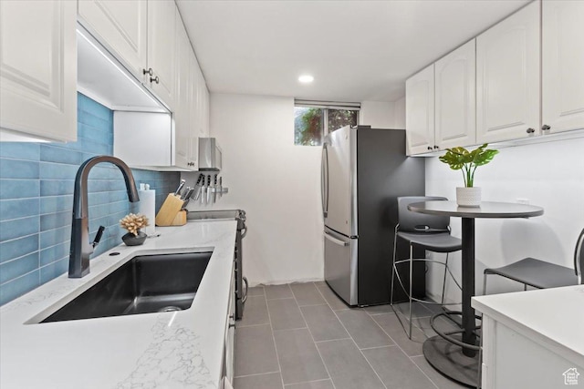4560 S Wallace Ln, Holladay, UT 84117 - kitchen with freestanding refrigerator, white cabinets, tasteful backsplash, tile patterned flooring, and recessed lighting