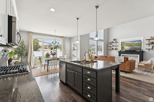 13698 S Black Hoof Cir, Herriman, UT 84096 - kitchen featuring appliances with stainless steel finishes, dark wood-style floors, dark stone countertops, a kitchen bar, and pendant lighting