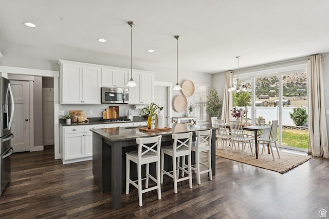 13698 S Black Hoof Cir, Herriman, UT 84096 - kitchen featuring stainless steel appliances, an island with sink, white cabinets, dark wood finished floors, and recessed lighting