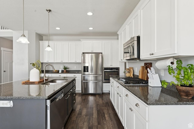 13698 S Black Hoof Cir, Herriman, UT 84096 - kitchen with appliances with stainless steel finishes, dark wood-style flooring, white cabinets, recessed lighting, and hanging light fixtures