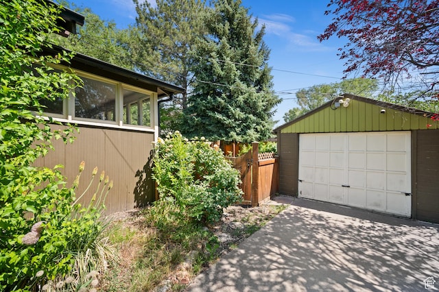 832 E Ramona Ave, Salt Lake City, UT 84105 - view of side of home featuring concrete driveway, a detached garage, an outdoor structure, and a sunroom