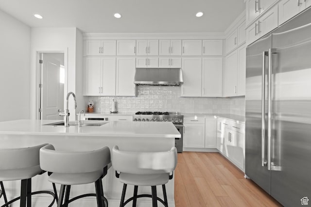 4473 N Solstice Dr, Lehi, UT 84043 - kitchen featuring high quality appliances, extractor fan, light countertops, a breakfast bar, and white cabinetry