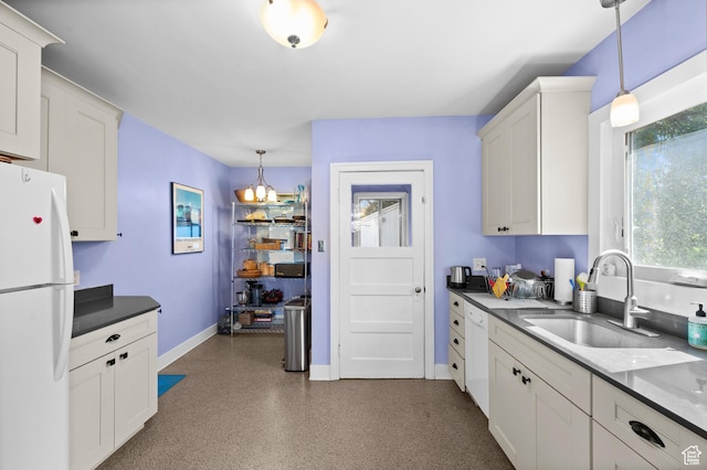454 E Bryan Ave, Salt Lake City, UT 84115 - kitchen featuring freestanding refrigerator, hanging light fixtures, a chandelier, dark countertops, and white cabinetry