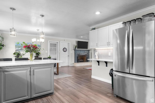 1775 S 290 E, Orem, UT 84058 - kitchen featuring freestanding refrigerator, light countertops, ornamental molding, tasteful backsplash, and white cabinets