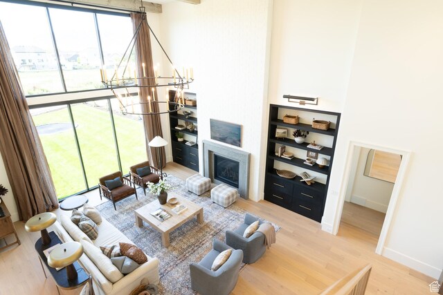 1889 W 1400 S, Lehi, UT 84043 - living area with light wood-type flooring, a chandelier, a glass covered fireplace, and built in shelves