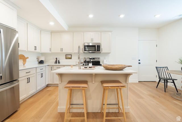 1889 W 1400 S, Lehi, UT 84043 - kitchen with stainless steel appliances, a kitchen breakfast bar, light wood finished floors, light countertops, and recessed lighting