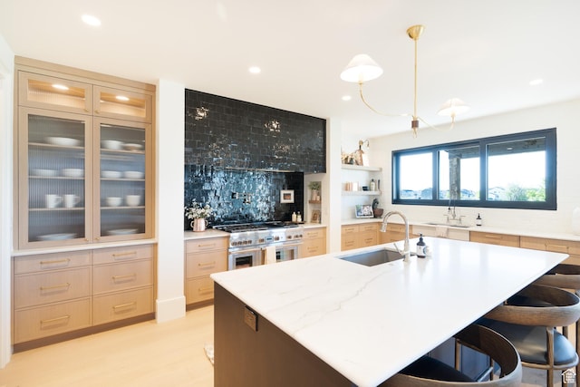 1889 W 1400 S, Lehi, UT 84043 - kitchen with range with two ovens, recessed lighting, a breakfast bar, decorative backsplash, and an island with sink