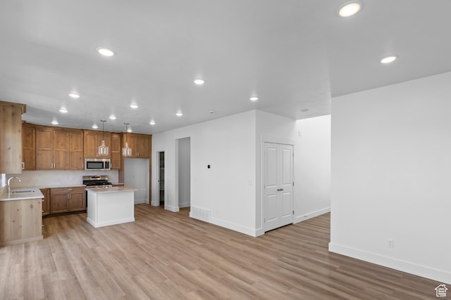 223 E 580 N, Providence, UT 84332 - kitchen with appliances with stainless steel finishes, light countertops, recessed lighting, light wood-style floors, and a center island