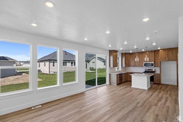 223 E 580 N, Providence, UT 84332 - kitchen with appliances with stainless steel finishes, recessed lighting, light countertops, light wood-style flooring, and a center island