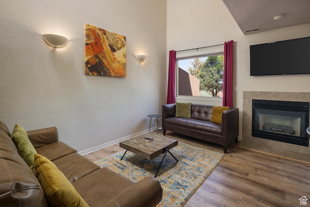 3287 E Fairway Loop, Moab, UT 84532 - living area featuring a tiled fireplace, wood finished floors, and vaulted ceiling