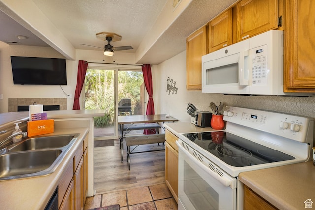 3287 E Fairway Loop, Moab, UT 84532 - kitchen with white appliances, a ceiling fan, brown cabinets, light countertops, and a textured ceiling