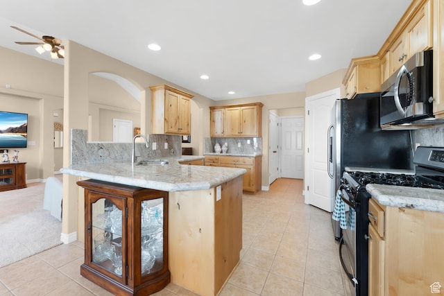 328 S 1060 E, Santaquin, UT 84655 - kitchen with stainless steel microwave, black gas stove, light brown cabinets, a peninsula, and light tile patterned floors