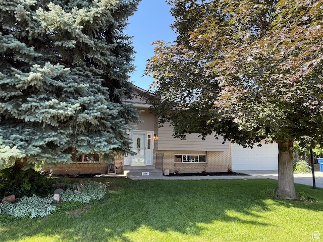 3841 W Bluebird Cir, West Valley City, UT 84120 - view of property hidden behind natural elements with brick siding, a front lawn, and driveway