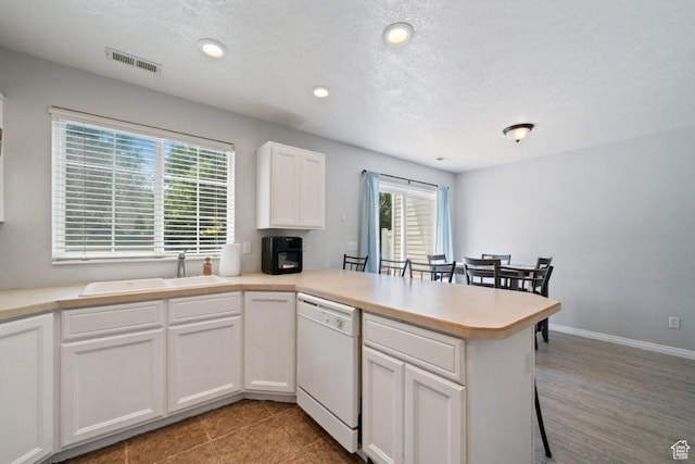 1021 Sara Ln, Ogden, UT 84404 - kitchen featuring white dishwasher, a peninsula, white cabinets, healthy amount of natural light, and recessed lighting