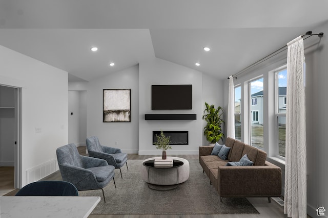 233 E 580 N, Providence, UT 84332 - living room featuring wood finished floors, a glass covered fireplace, vaulted ceiling, and recessed lighting