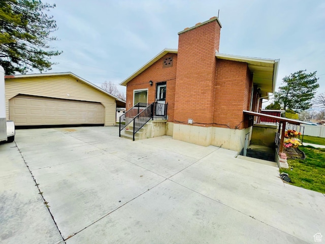 1086 W Wenco Dr S, Salt Lake City, UT 84104 - view of property exterior featuring a chimney, an outdoor structure, a garage, and brick siding