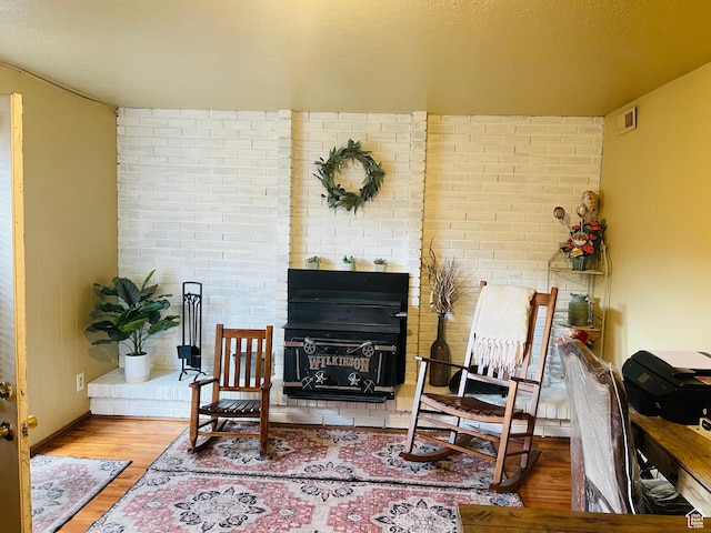 1086 W Wenco Dr S, Salt Lake City, UT 84104 - sitting room featuring wood finished floors and brick wall