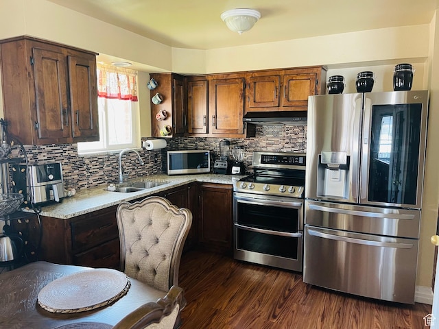 1086 W Wenco Dr S, Salt Lake City, UT 84104 - kitchen with appliances with stainless steel finishes, under cabinet range hood, dark wood-style floors, and decorative backsplash