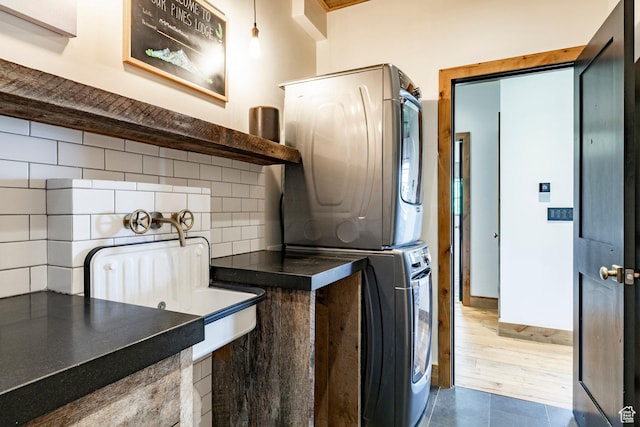 1766 W Arapaho Dr, Wanship, UT 84017 - laundry room with stacked washing machine and dryer and dark tile patterned floors