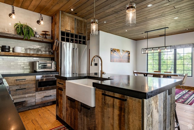 1766 W Arapaho Dr, Wanship, UT 84017 - kitchen featuring appliances with stainless steel finishes, light wood-style flooring, dark countertops, wooden ceiling, and a center island with sink