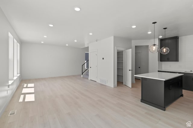 216 E 610 N, Providence, UT 84332 - kitchen with a kitchen island, recessed lighting, light countertops, dark cabinets, and light wood-style floors
