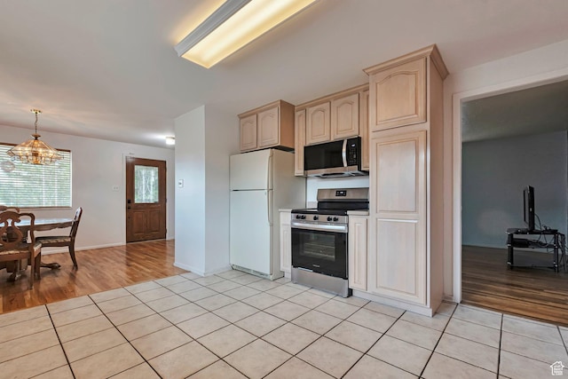 4683 W 3855 S, West Valley City, UT 84120 - kitchen featuring stainless steel appliances, light tile patterned floors, light brown cabinets, a chandelier, and decorative light fixtures