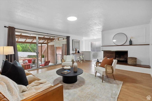 1881 S Foothill Dr E, Salt Lake City, UT 84108 - living area featuring a textured ceiling, a brick fireplace, and wood finished floors
