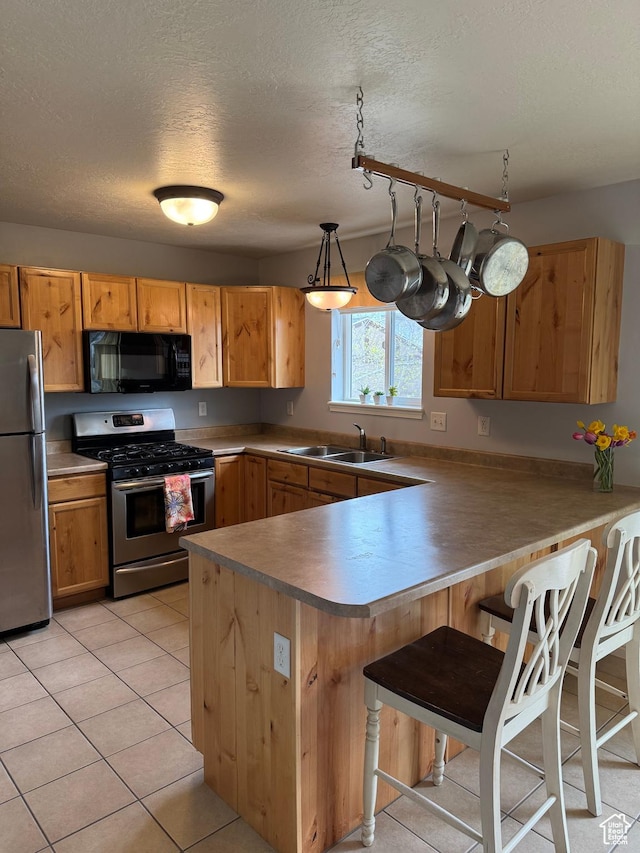 471 N 100 W, Kamas, UT 84036 - kitchen featuring appliances with stainless steel finishes, a peninsula, a breakfast bar, a textured ceiling, and light tile patterned floors