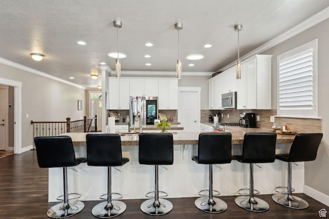 5673 S Wilson View Ct, Holladay, UT 84121 - kitchen featuring stainless steel appliances, decorative backsplash, ornamental molding, a peninsula, and white cabinetry