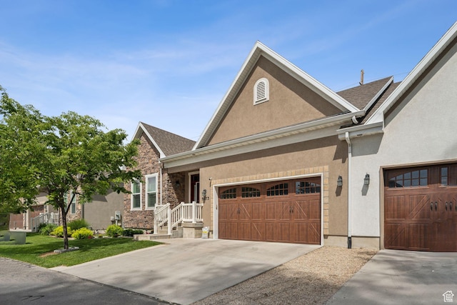 5673 S Wilson View Ct, Holladay, UT 84121 - view of front of home with stucco siding, driveway, a front lawn, an attached garage, and roof with shingles