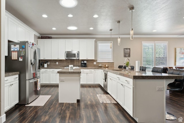 5673 S Wilson View Ct, Holladay, UT 84121 - kitchen featuring appliances with stainless steel finishes, crown molding, a breakfast bar, a peninsula, and decorative backsplash